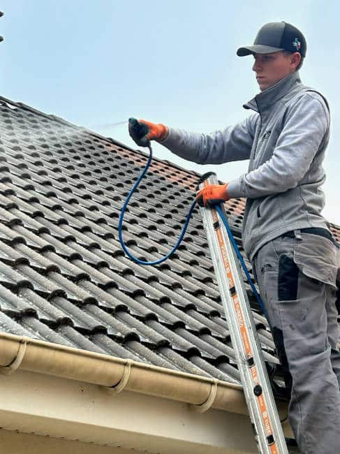 Enzo entrain de nettoyer une toiture dans l'Essonne 91