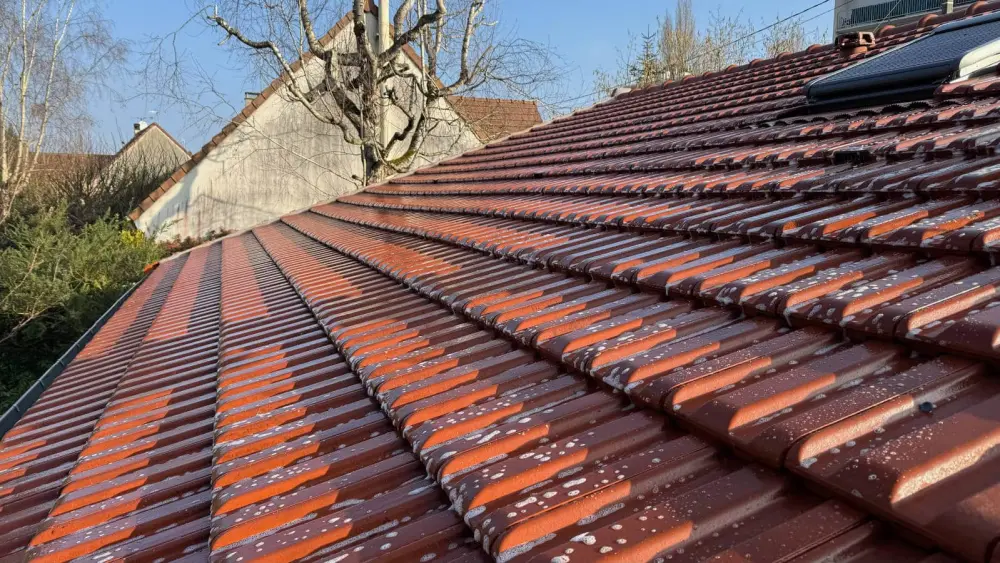 Toiture en tuiles rouges sur une maison de La Ville-du-Bois